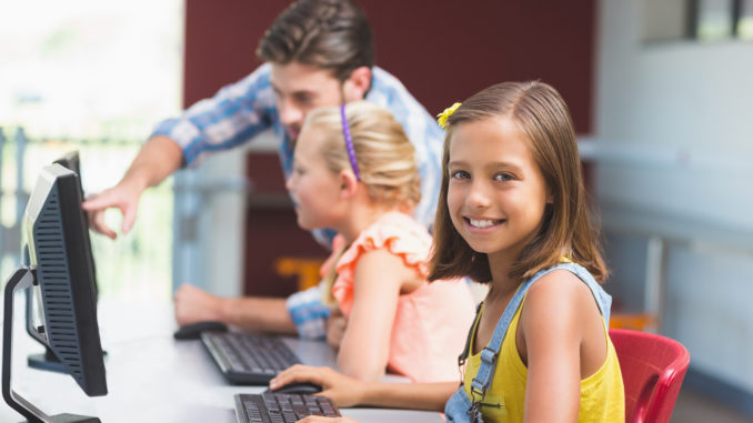 Schoolgirl using computer in classroom at school